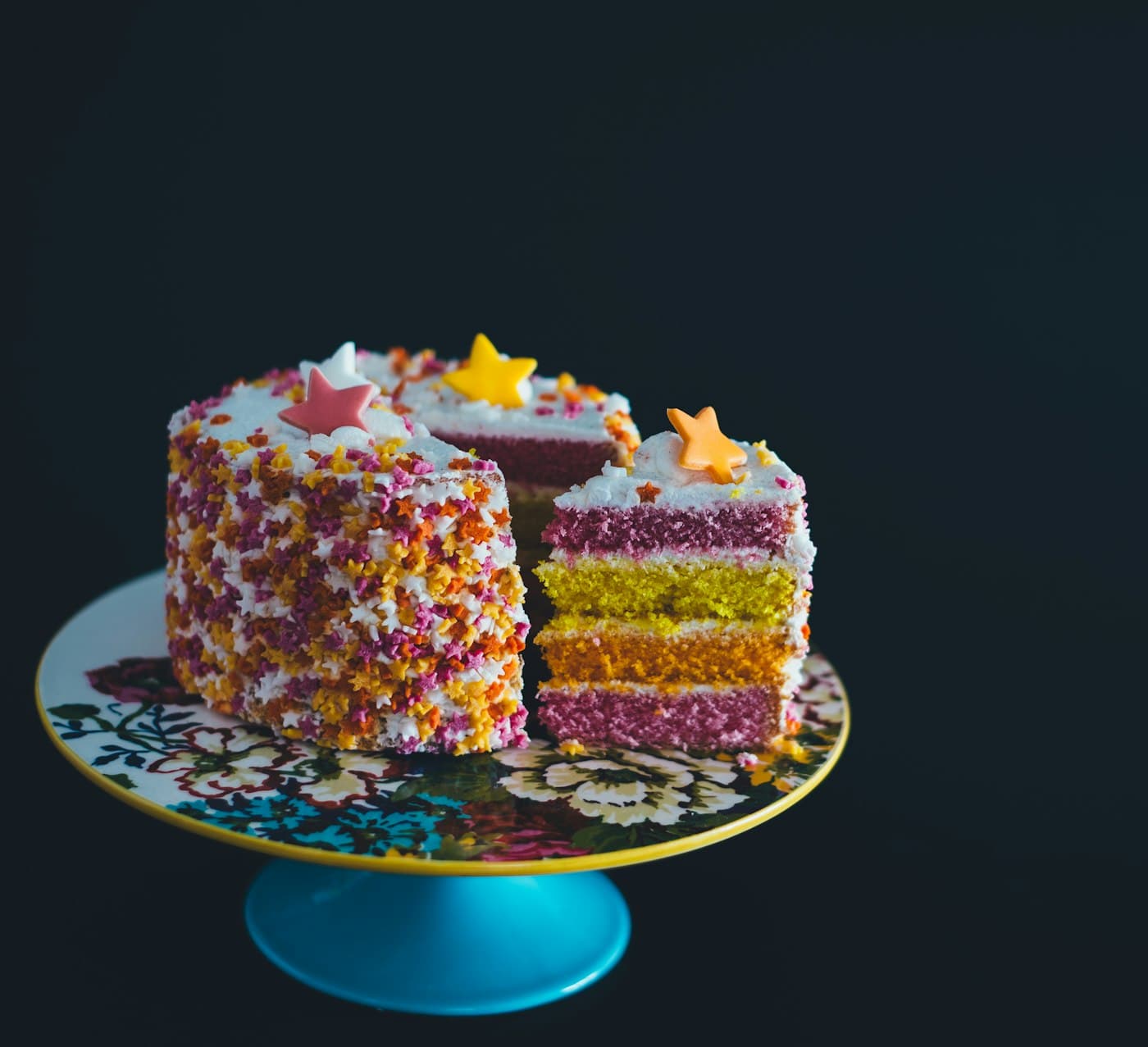 A cake with tall candles in a dim room